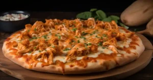 Buffalo Chicken Pizza with melted cheese and fresh herbs on a wooden board